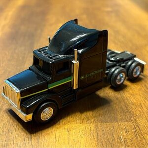 Vintage ERTL Peterbilt 1:64 John Deere black dual axle diecast semi-truck.